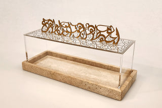 Image Alhambra Dessert Box Clear acrylic dessert box on Travertine marble tray and gold Metal Calligraphy on white Background.