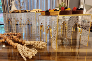 Image Zoom in side view of Anater Food Riser showing set of 2 sizes acrylic Turkish printed white and gold risers on dinning table with food display and decoration